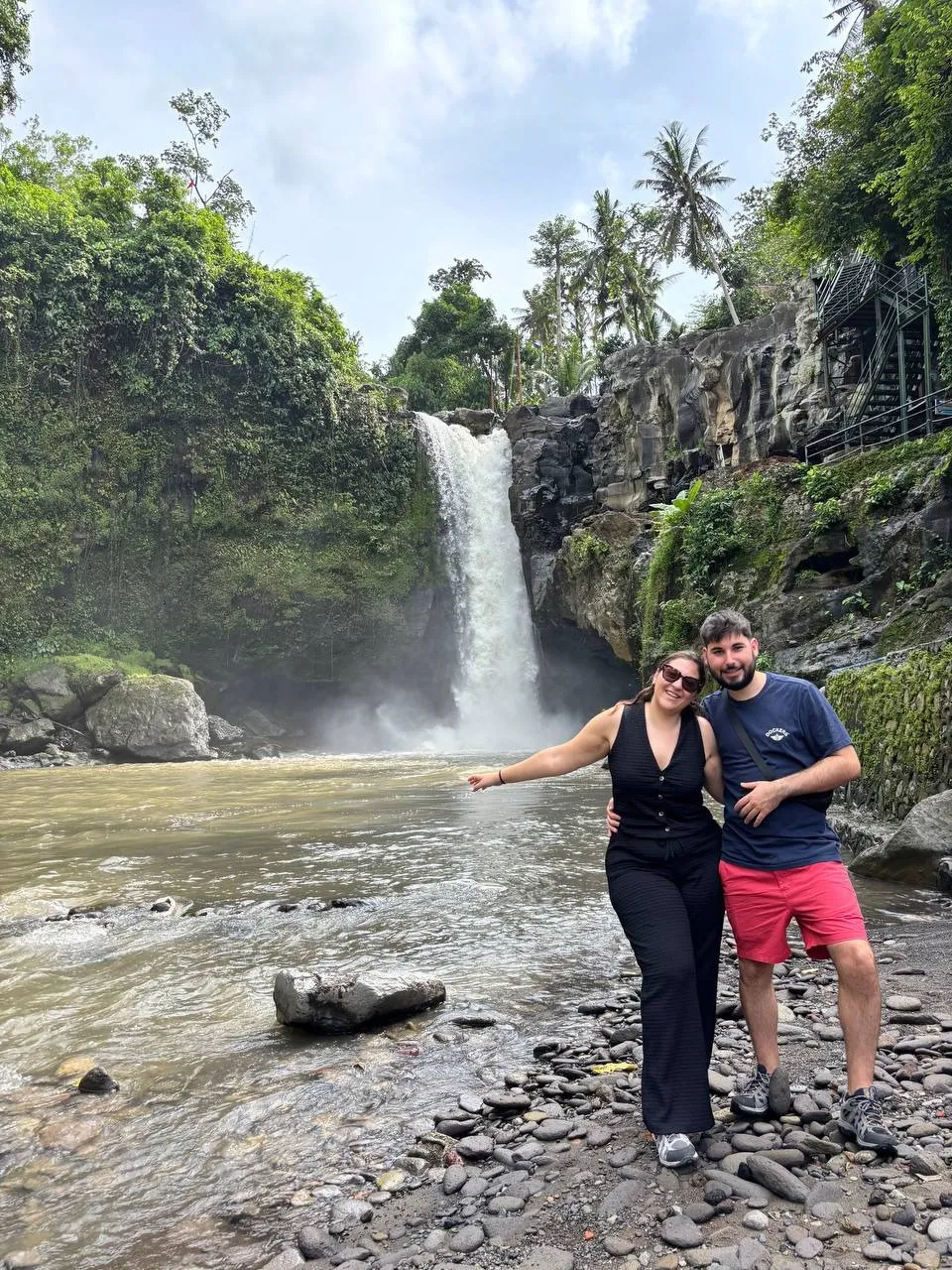 Somrient al peu d'un salt d'aigua a Bali